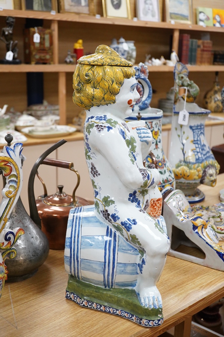 A large Brussels style faience Bacchus figural wine cistern, 62cm high